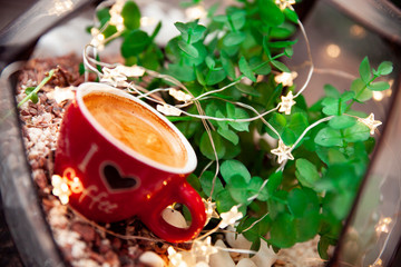 A cup of coffee lies behind a glass