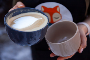 Barista holds 2 cups of coffee in his hands