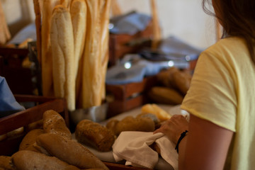 Woman cutting bread in hotel breakfast buffet.