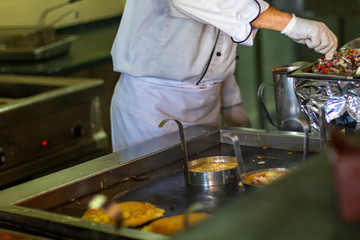 The chef bakes omelettes in the open kitchen of the hotel.