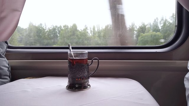 Glass of tea on a train compartment table.