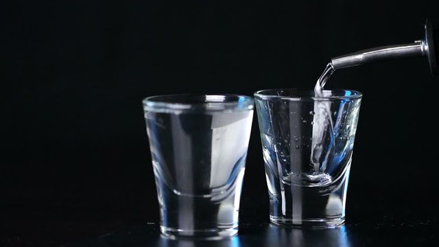 alcohol vodka poured in glasses on a dark background