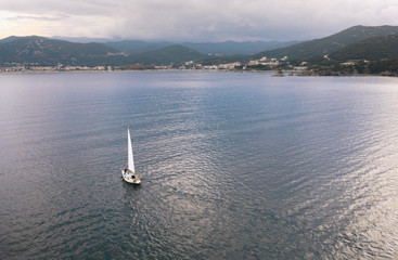 Aerial view of sailboat in the sea at overcast day.