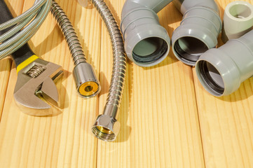 Spare parts and accessories for plumbing repair on a wooden background