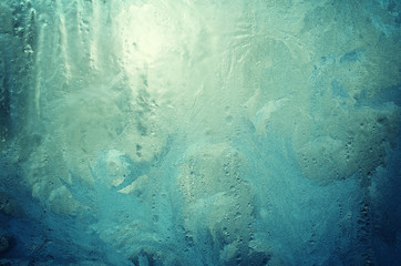 Fantastic fairy-like frost pattern on the window glass (as an abstract winter background), retro toned