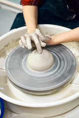 Woman making ceramic pottery on wheel, hands closeup. Concept for woman in freelance, business,...