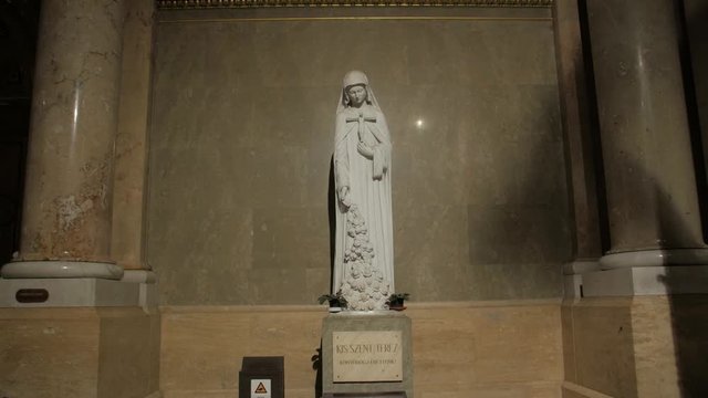 Woman catholic statue saint Therese of Lisieux by Beni Ferenczy crucifix in hands St. Stephen's Basilica in Budapest Hungary smooth dolly push in camera movement