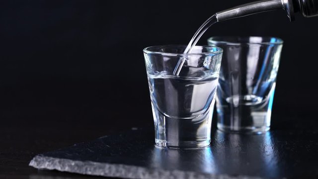 alcohol vodka poured in glasses on a dark background