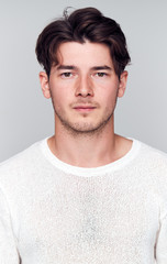 Fototapeta premium Studio Portrait Of Young Man With Serious Expression Looking At Camera