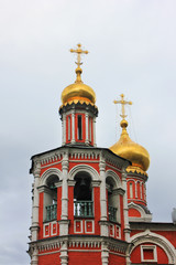 Fototapeta na wymiar Orthodox church decorative architecture with bell tower and golden domes with religious cross in Moscow, Russia
