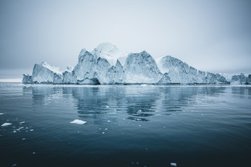Iceberg and ice from glacier in arctic nature landscape in Ilulissat,Greenland. Aerial drone photo of icebergs in Ilulissat icefjord. Affected by climate change and global warming. - obrazy, fototapety, plakaty