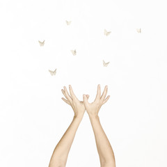woman's hands dance in harmony with some origami butterflies