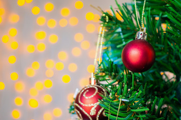 Christmas tree decorated with red ball on pine branches background