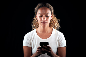 Studio Shot Of Unhappy Woman Holding Mobile Phone Being Bullied Online
