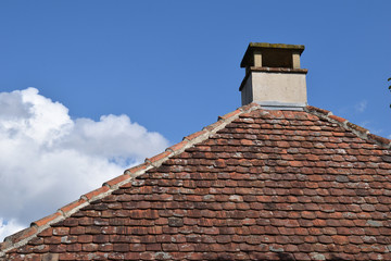 Stone Chimney on Roof with Weathered Terracotta Tiles 