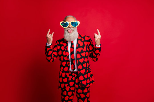 Portrait of his he nice attractive funky crazy cheerful naughty white-haired guy hipster showing heavy metal rock roll sign fooling isolated on bright vivid shine vibrant red color background