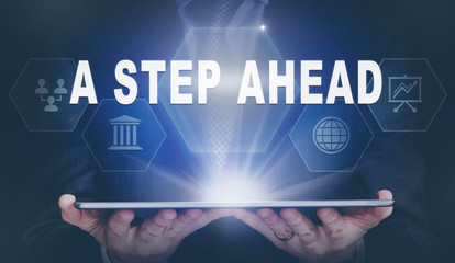 Businessman holding a computer tablet display projecting a A step Ahead concept.