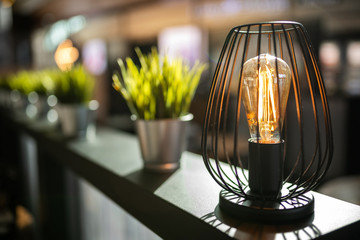 Incandescent lamp in a stylish interior with sunlight.