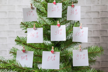 Christmas sale label set on the white paper stickers on the Christmas tree. Winter discounts, shopping promotion Concept