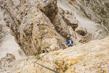 Wspinaczka po via ferrata - włoskie Alpy. Turystyka górska w Dolomitach.