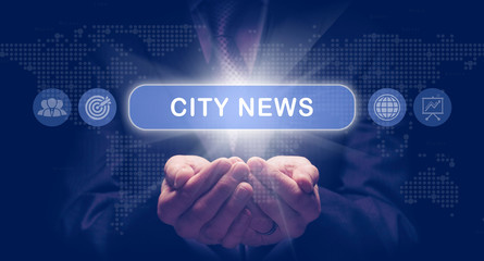 Businessmans cupped hands holding a City News business concept on a computerised display.