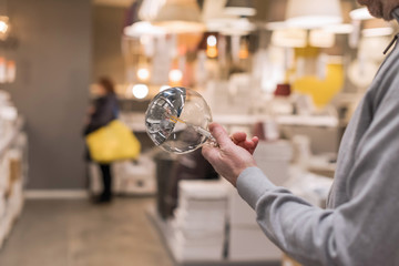 Man hand holding or selecting huge LED diode light bulb lamp in department store. Energy efficient lighting