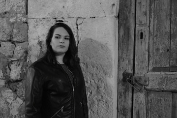 Portrait of Young Beautiful Woman Near the Wall by Night in the City