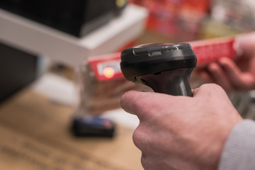 Customer with manual scanner of barcodes scans the scan discount card for buying in supermarket. self catering