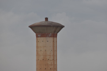 A top view of overhead cement concrete water storage tank, which supplies water to the rural living people. with the background of sky