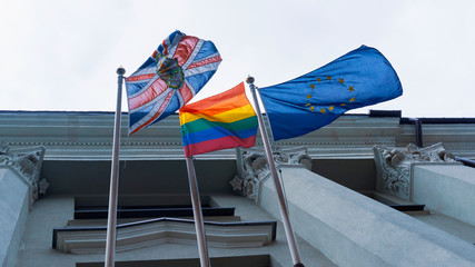 Rainbow flag or pride flag, union jack or Great Britain flag and United Europe flag on the facade of the building.