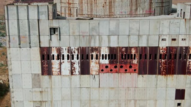 AERIAL SHOT Post Apocalyptic background from ferroconcrete wall Row of panels with rusty spots With around hat on the top