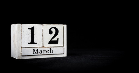 March 12th, Twelfth of March, Day 12 of month March - white calendar blocks on black textured background with empty space for text.