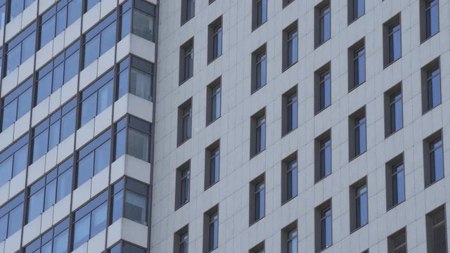 Exterior establishing shot of a apartment building. Residential building exterior with blue sky background. The building features exterior with small balconies
