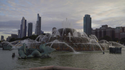 Famous buckingham fountain in Chicago park outside downtown with beautiful sunset skyline in...
