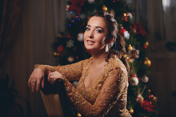 Beauty woman on new year background with lights bokeh in golden dress