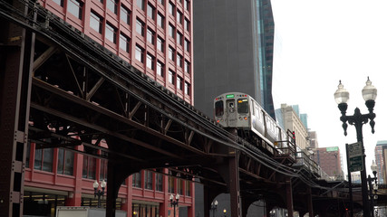 Chicago L train day time exterior establishing shot in front of downtown urban apartment buildings....