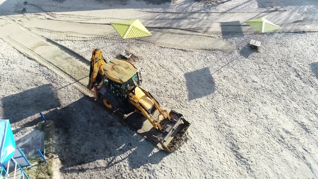Ukraine, Kiev, December 2, 2019, a tactor levels the soil, a tractor works on the beach. 4k aerial photography