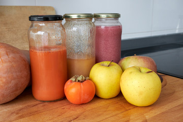 homemade carrot, pear and pomegranate juice in jars