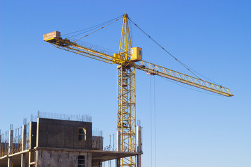 Fototapeta na wymiar bright yellow construction crane against the blue sky