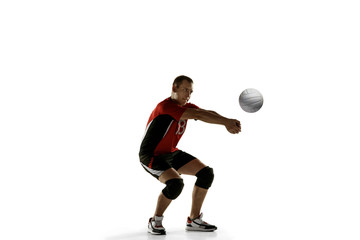 Fototapeta na wymiar Young caucasian volleyball player placticing isolated on white background. Male sportsman training with the ball in motion and action. Sport, healthy lifestyle, activity, movement concept. Copyspace.