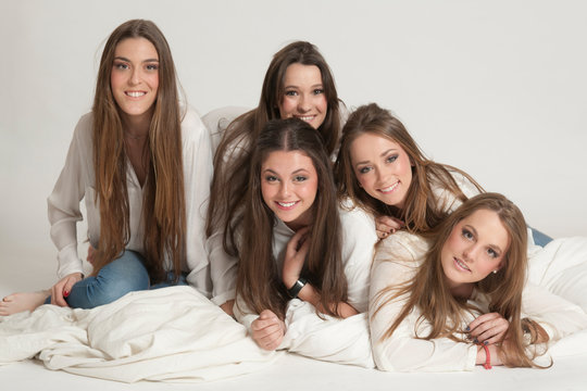 Group of happy girls seated and lying on the floor posing for a picture