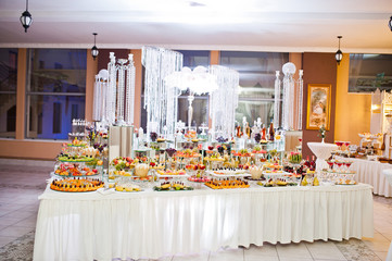 Fototapeta premium Dessert table of delicious sweets on wedding reception.