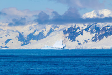 Fototapeta na wymiar Snow-capped mountains on an island along the coasts of the Antarctic Peninsula, Antarctica