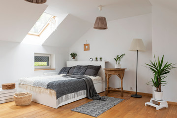 Modern bedroom interior of room with double bed and grey pillows. White bedroom in scandinavian...