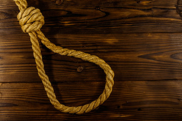 Deadly loop of rope on a wooden background. Concept of death penalty or suicide