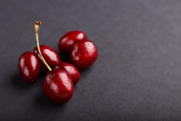 Ugly weird red sweet cherry on black background. side view. food concept.