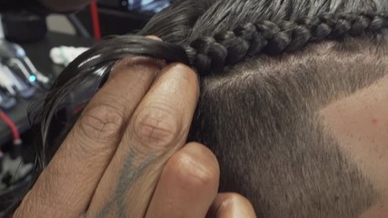 Braiding man's hair at barbershop