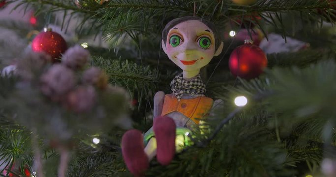 Close HDR shot of a string operated handmade ceramic puppet (marionette) from Prague (Czech Republic). Beautiful close up of this smiling tiny person sitting in a Christmas tree like an ornament.
