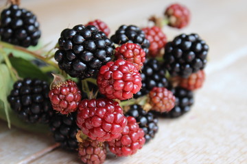 Multi-colored fruits of blackberry on wooden boards. Agriculture. Harvest