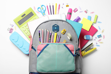 Stylish backpack with different school stationery on white background, top view - obrazy, fototapety, plakaty